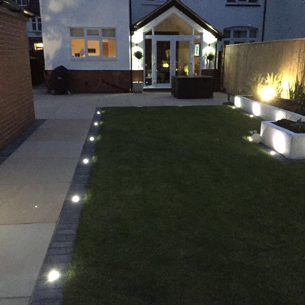 House with garden at night with light features created by MTS Landscaping