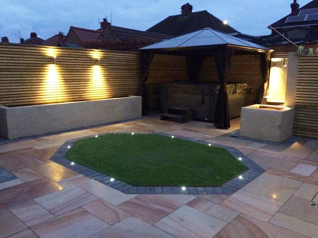 Paved patio and light features at night created by MTS Landscaping